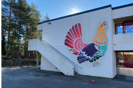 en hvit bygning med et fargerikt veggmaleri