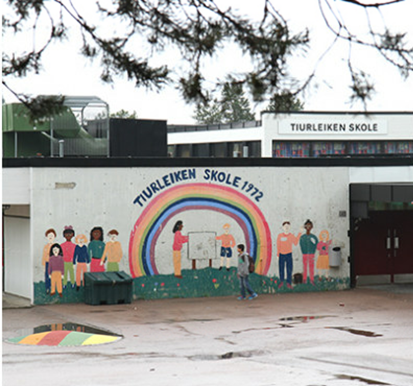 en gruppe mennesker som står på en vegg med en bygning i bakgrunnen