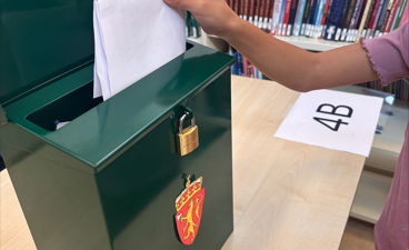 en person som holder et papir og en bok på et bibliotek