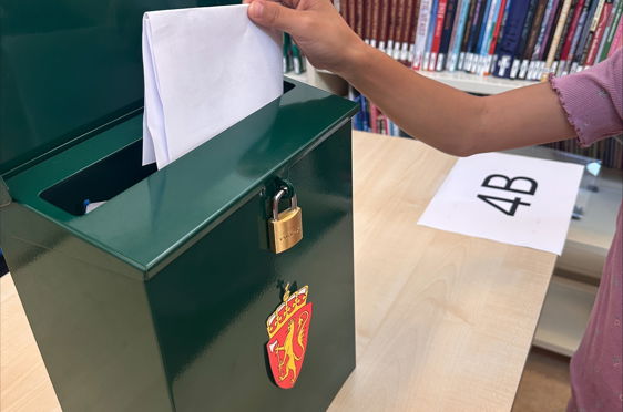 en person som holder et papir og en bok på et bibliotek
